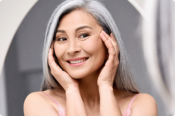 attractive mature woman looking at herself in mirror