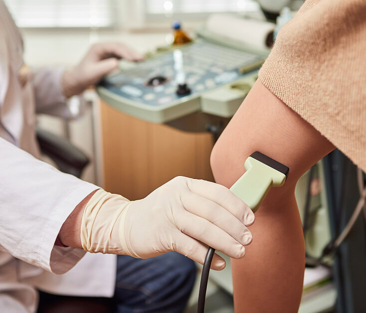 A specialist at a Boca Raton vein treatment center uses ultrasound for varicose vein exam.