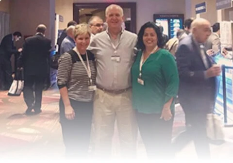 Three people at a Boca Raton vein treatment center conference networking.