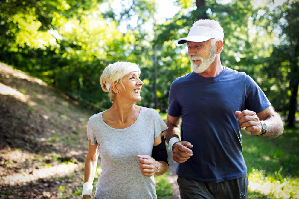 Happy older couple on a walk at a park during the summer.