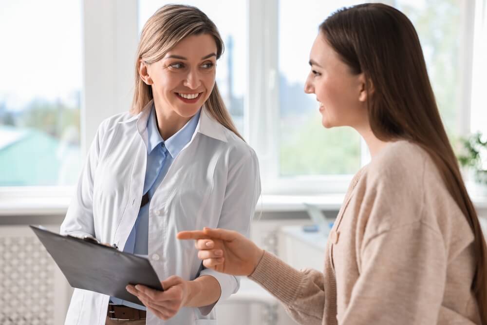 A vein specialist discussing hand vein treatment options with a patient