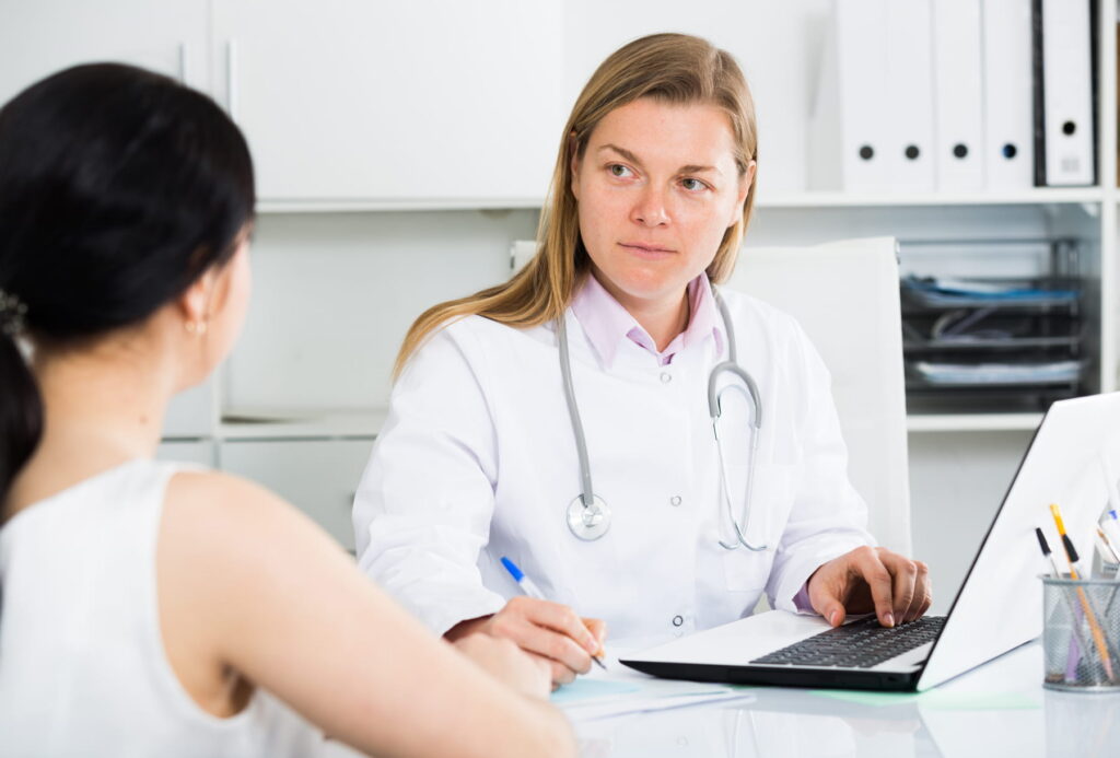 A vein specialist in Boca Raton discusses vein treatment options with a patient.