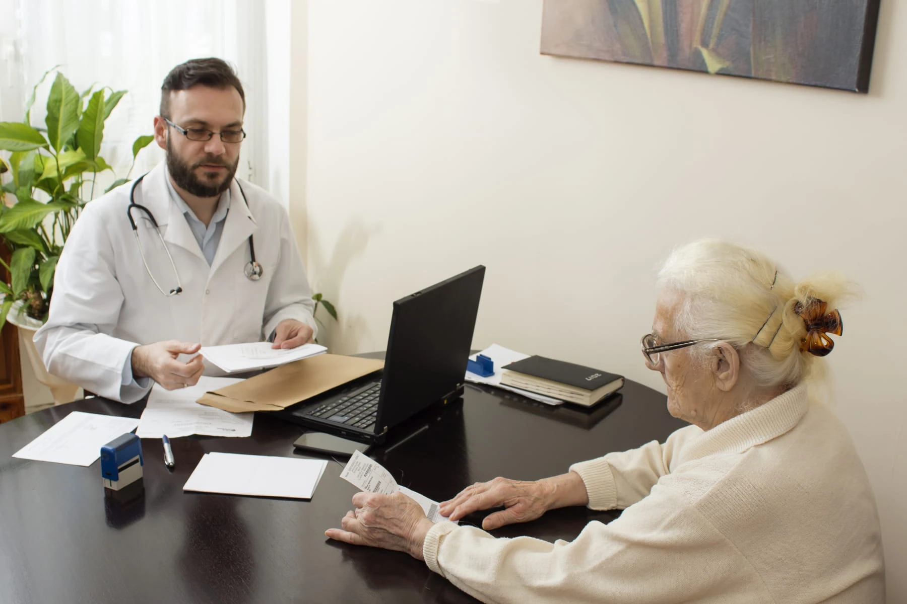 An elderly woman discusses vein disease treatment options with a doctor in a Boca Raton vein center.