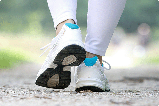 close-up of woman in sneakers walking on trail